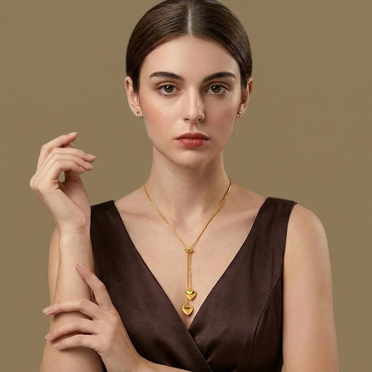 Woman wearing a gold necklace with a brown background