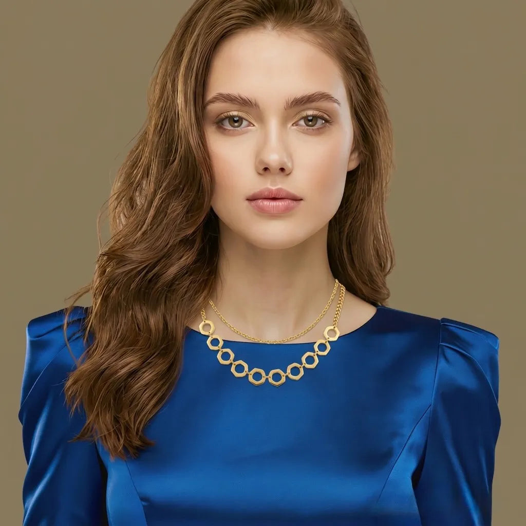 Woman wearing a blue dress and gold necklace against a beige background