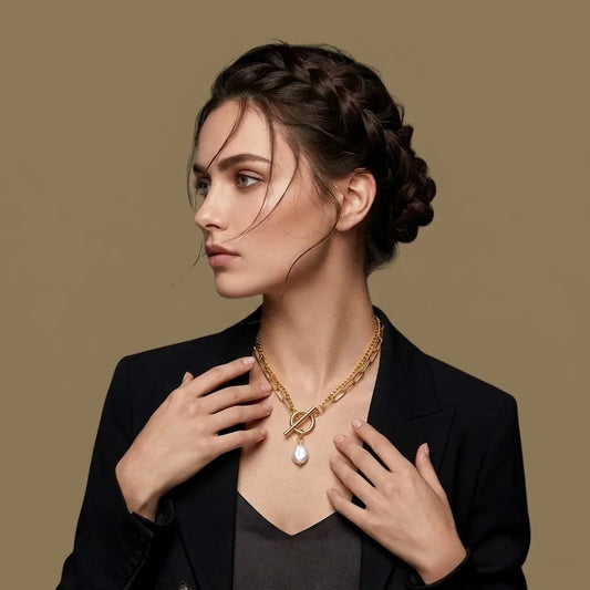 Woman wearing a gold necklace with a pendant against a brown background