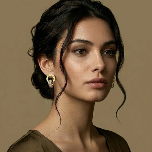 Woman wearing roman clock gold earrings against a beige background