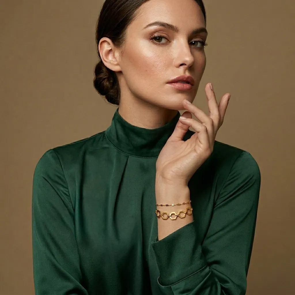 Woman wearing a green top and gold jewelry against a brown background