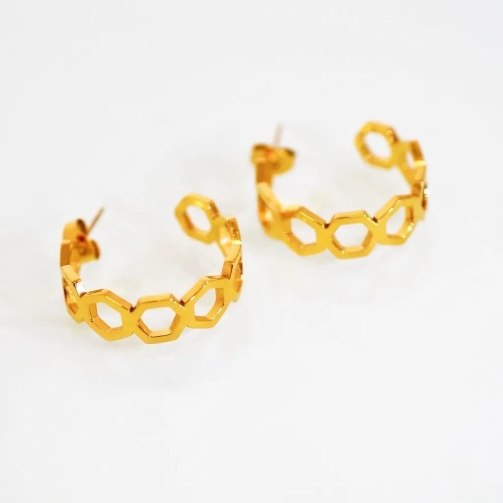 Gold hoop earrings with hexagonal design on a white background
