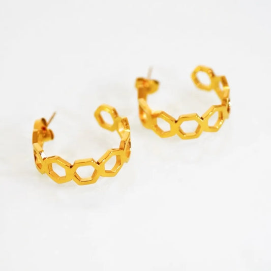 Gold hoop earrings with hexagonal design on a white background