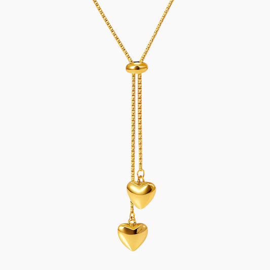 Gold necklace with heart-shaped pendants on a white background