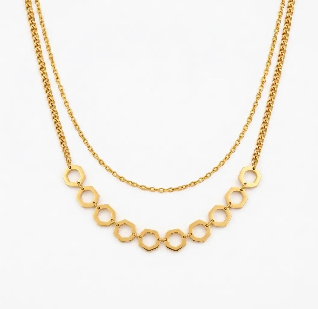 Gold necklace with geometric links on a white background