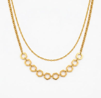 Gold necklace with geometric links on a white background
