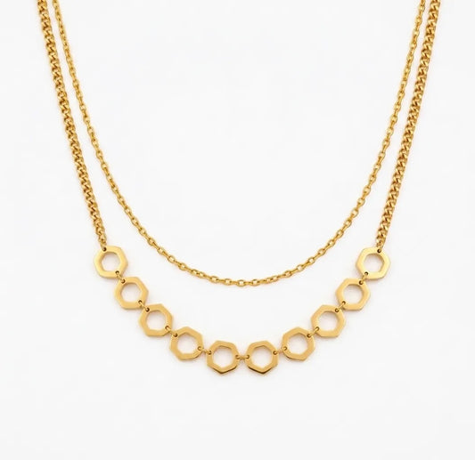 Gold necklace with geometric links on a white background