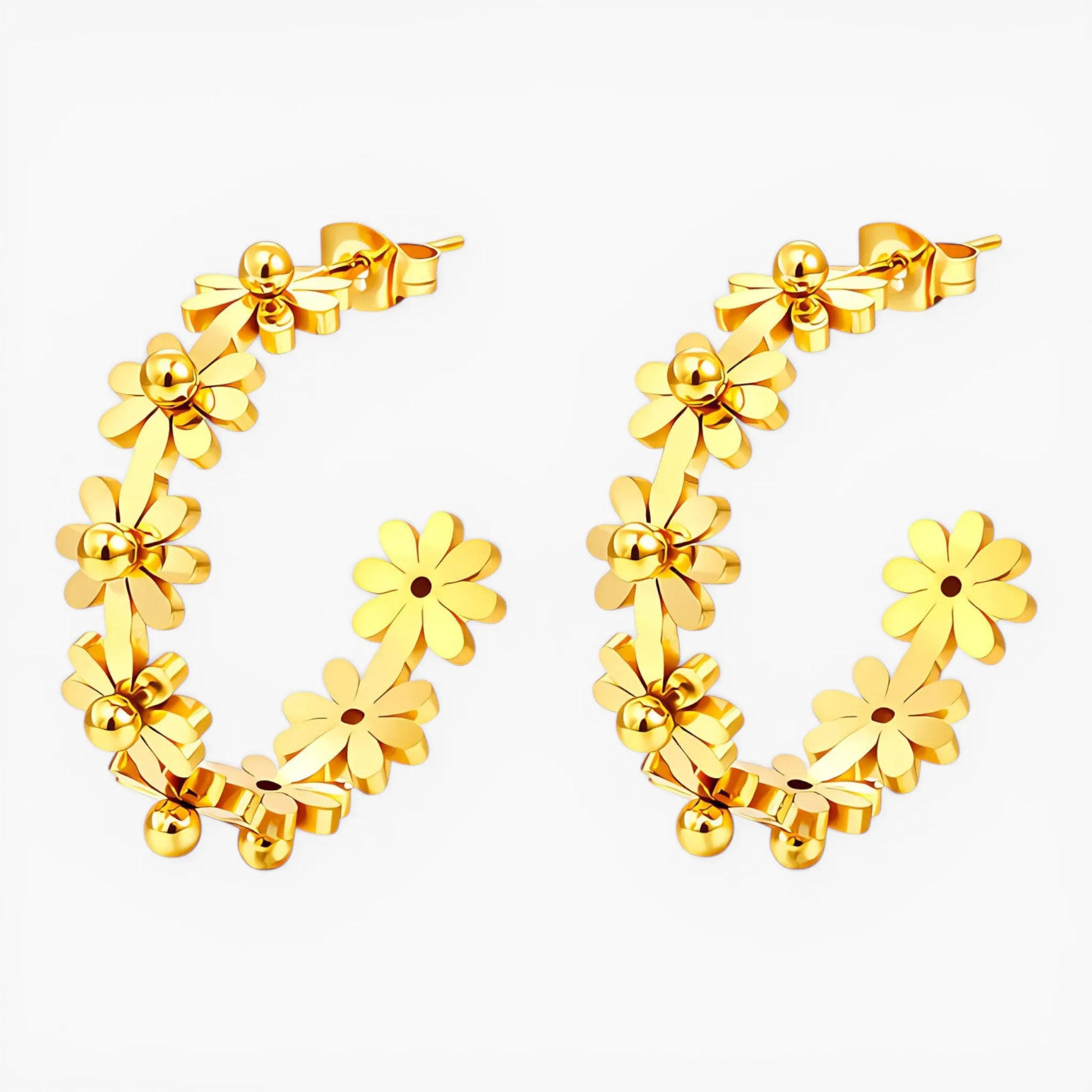 Gold hoop earrings with floral designs on a white background