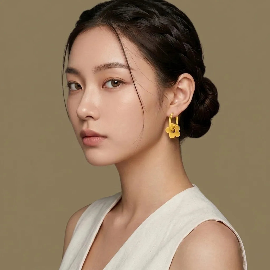 Woman wearing yellow floral gold hoop earrings, waterproof jewelry by Raline Bergemann