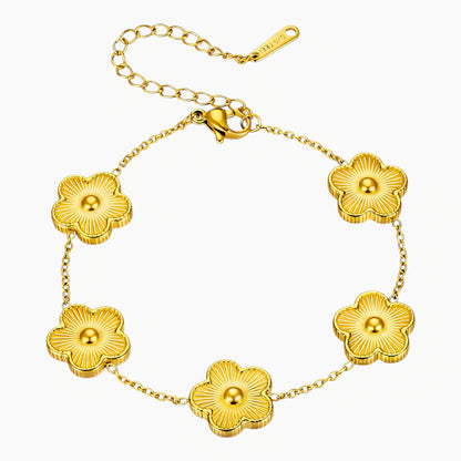 Gold bracelet with floral designs on a white background