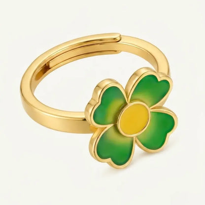 Gold ring with a green clover-shaped design on a white background