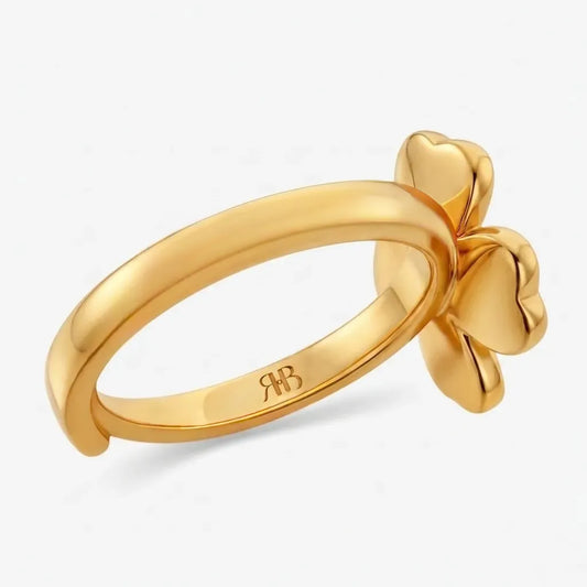 Gold ring with a bow design on a white background