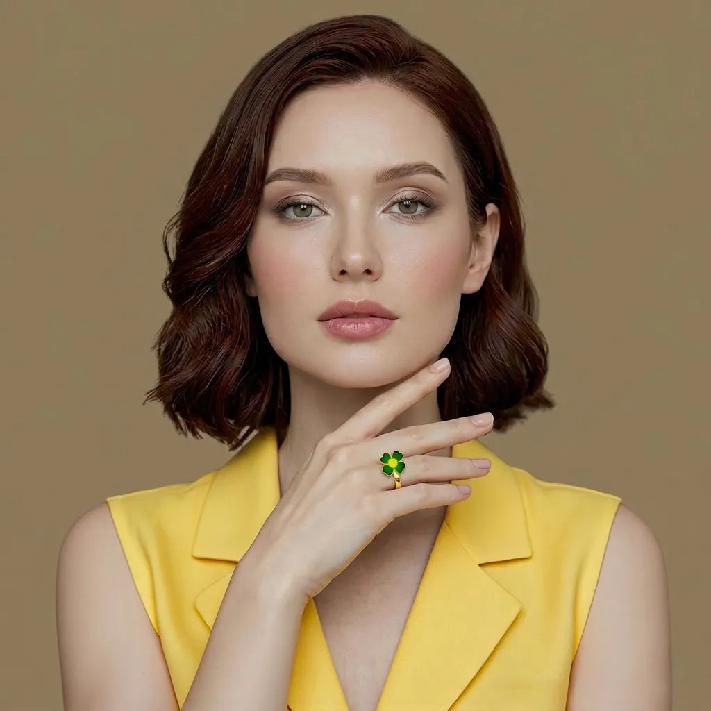 Woman wearing a yellow sleeveless top with a green ring on her finger against a brown background