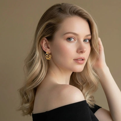 Woman wearing gold infinity heart hoop earrings, waterproof jewelry by Raline Bergemann