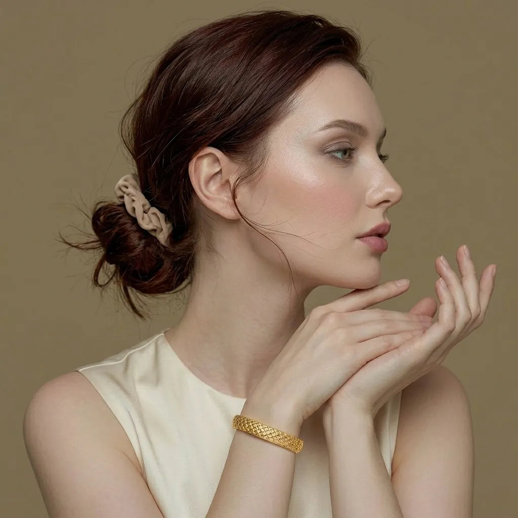 Woman wearing the gold quilted Lumière statement bangle, waterproof jewelry