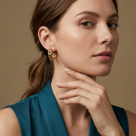 Woman wearing hexagon-shaped gold earrings with a golden background