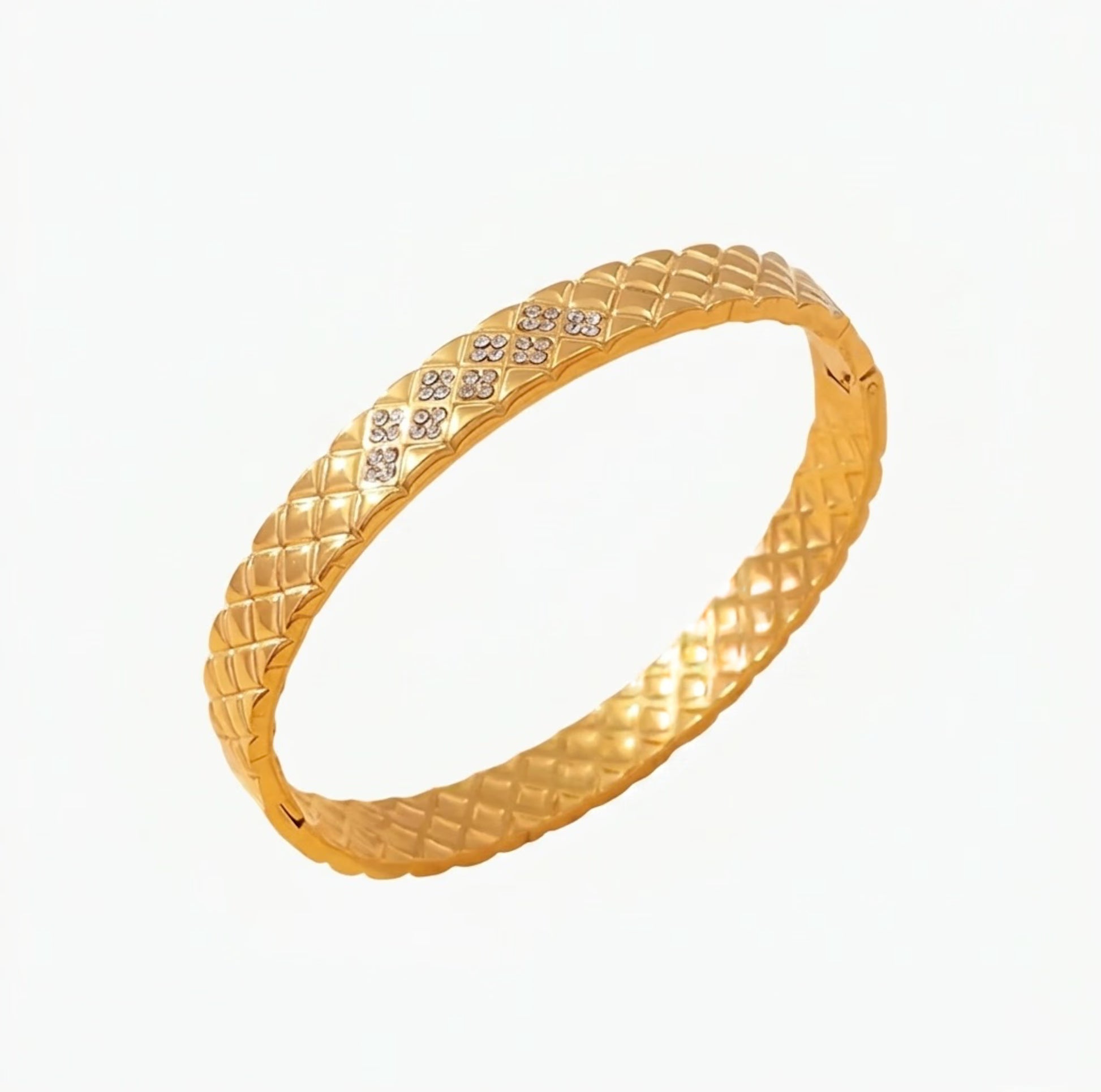 Gold bracelet with cushion textured design with crystals on a white background
