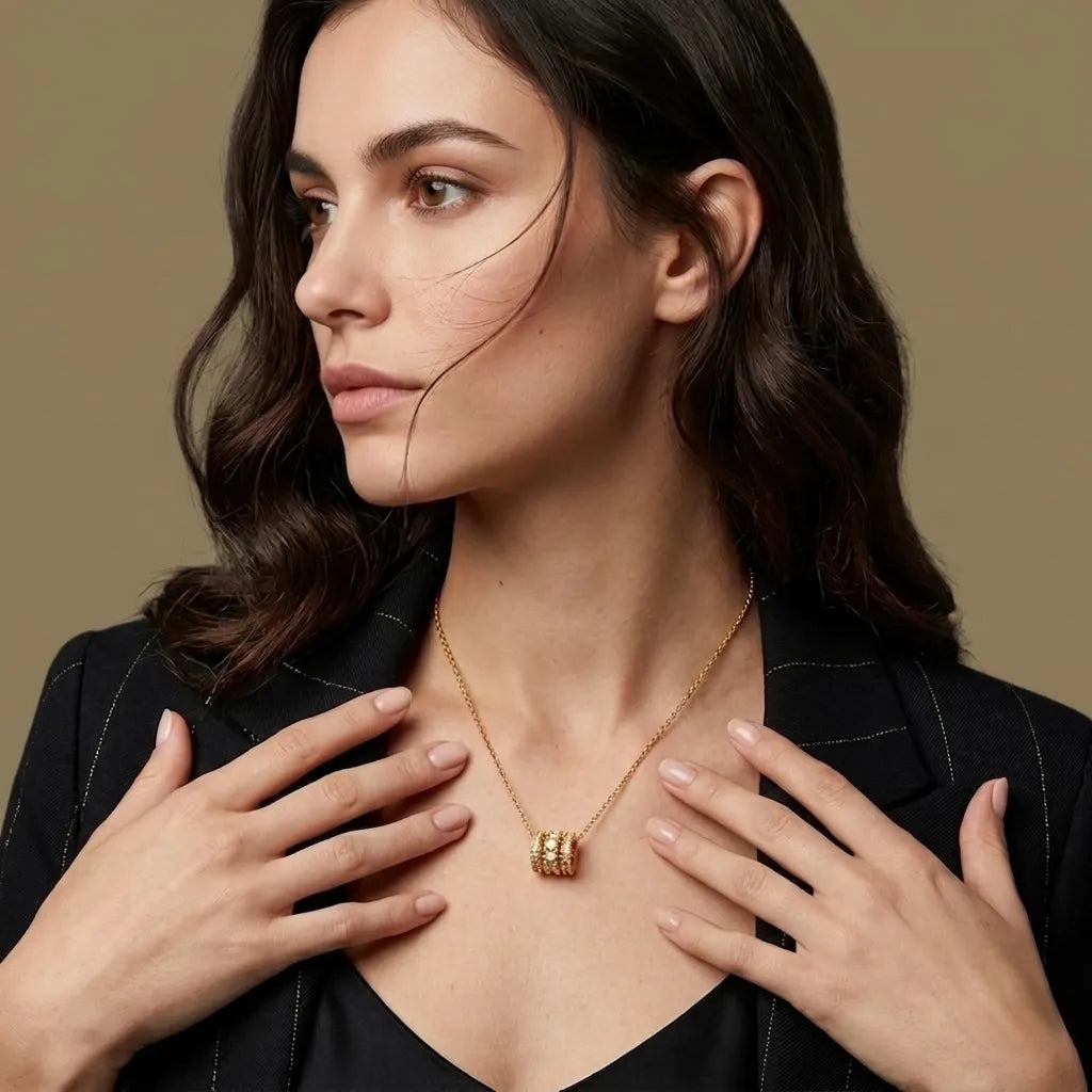 Woman wearing a gold necklace with a beige background