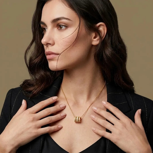 Woman wearing a gold necklace with a beige background