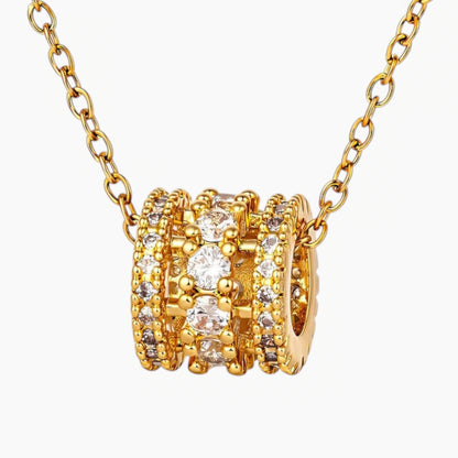 Gold necklace with multiple rings and diamonds on a white background