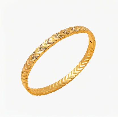 Gold bracelet with letter V design on a white background