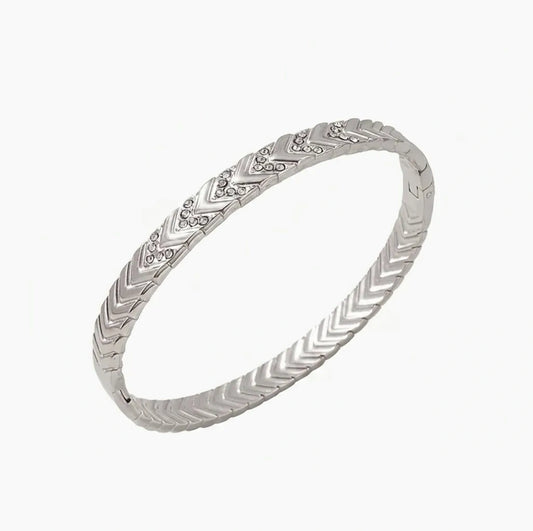 Silver bracelet with intricate design on a white background