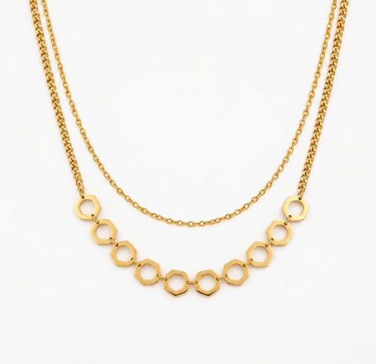 Gold necklace with geometric links on a white background